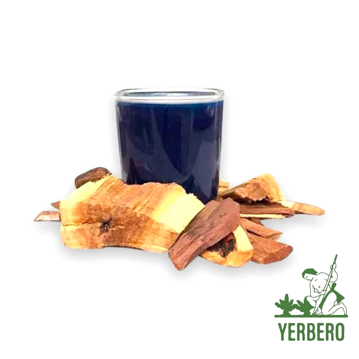 A glass of deep blue palo azul tea beside pieces of pale bark and wood